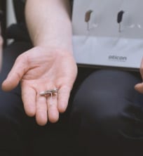 Man displaying hearing aid options
